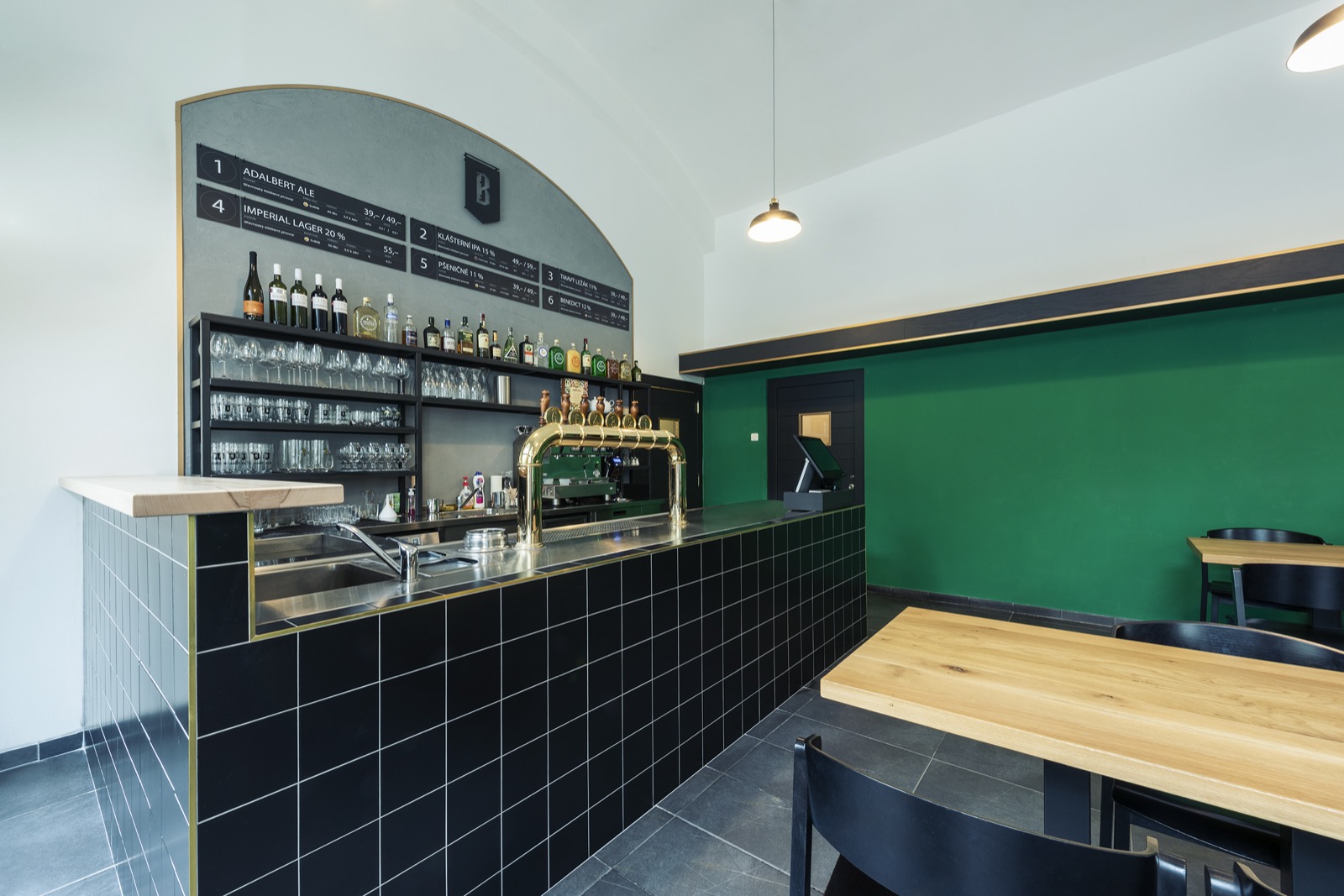 The bar counter of Pivovarský klub with the tap, glassware and the beer list on the board.